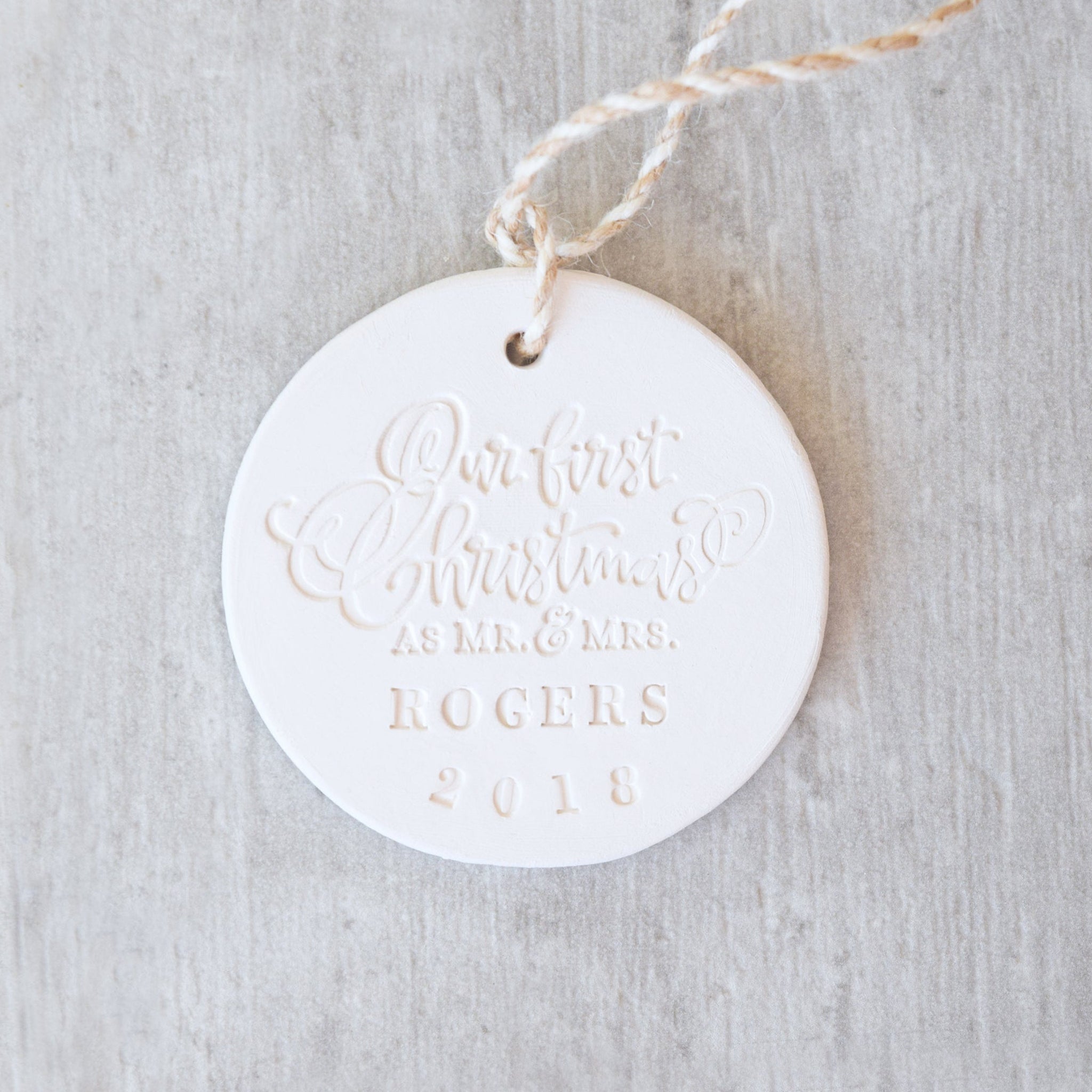 handmade pottery engraved newlywed couples mr mrs personalize family name ornament with our first christmas in fancy script font, tree trimming hanging decor, newlywed gift 1st anniversary present, ceramic clay art 3.5 inch round disc, nostalgia