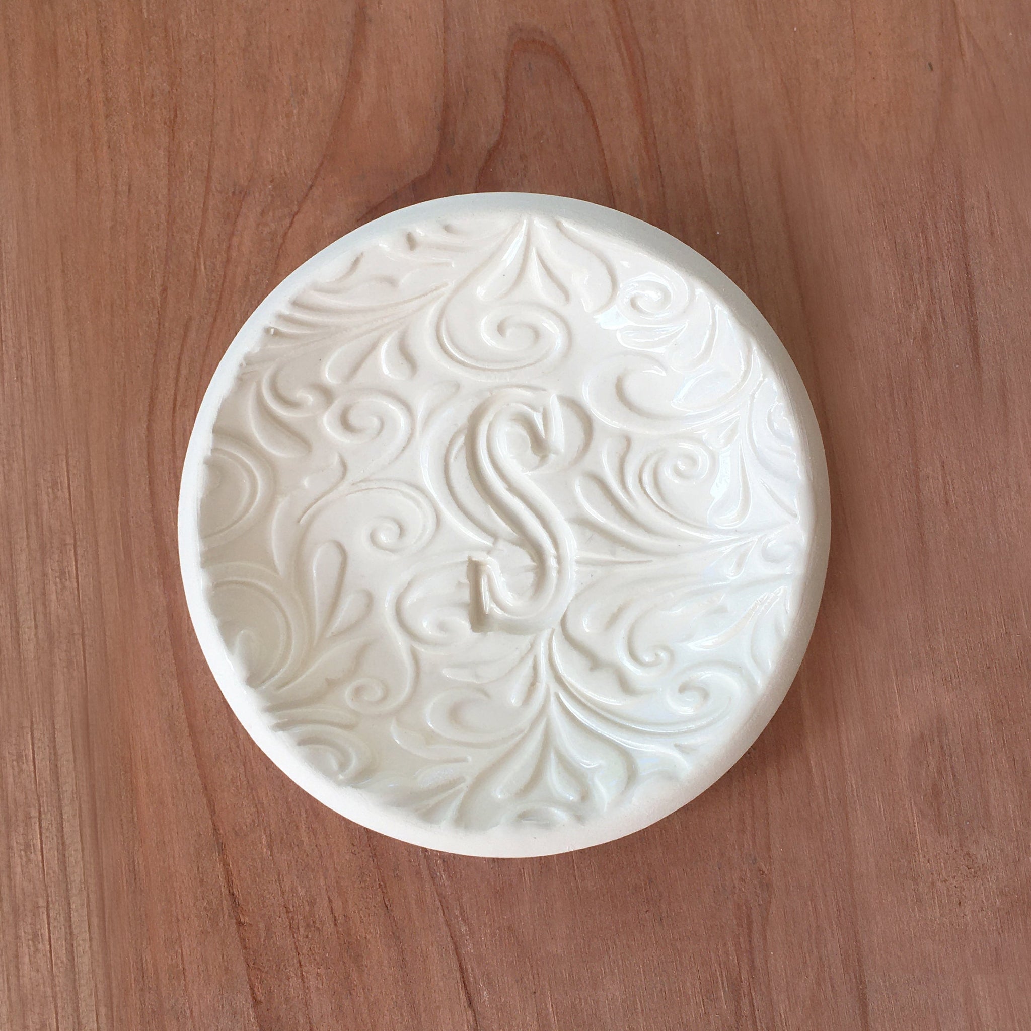 Handmade white ceramic bowl with engraved decorative patterns on a wooden surface, personalized ring holder jewelry tray with a custom letter stamped in clay. Unique weddings gift, engagement ring dish, teen, girlfriend women's birthday present
