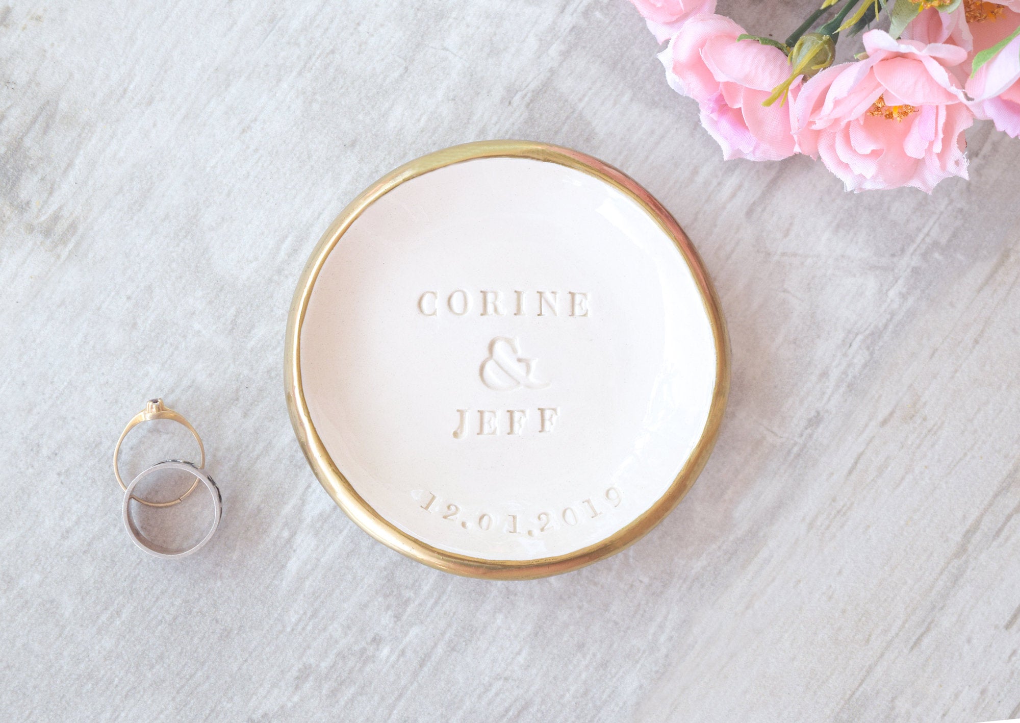 handmade ceramic ring dish features embossed names and date, hand painted gold trim white gloss finish bowl, personalize wedding ring holder couples wedding gift and heirloom anniversary keepsake. 